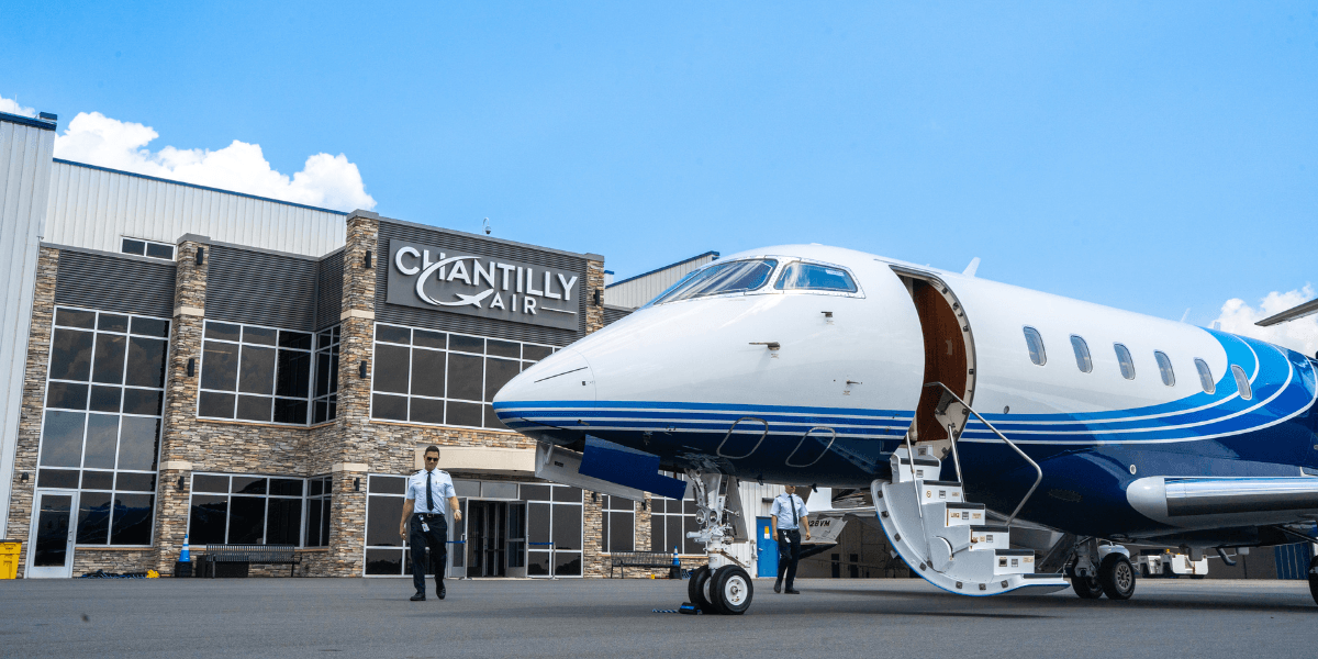 A pilot walking out of the Chantilly Air Jet Center to a private aircraft.