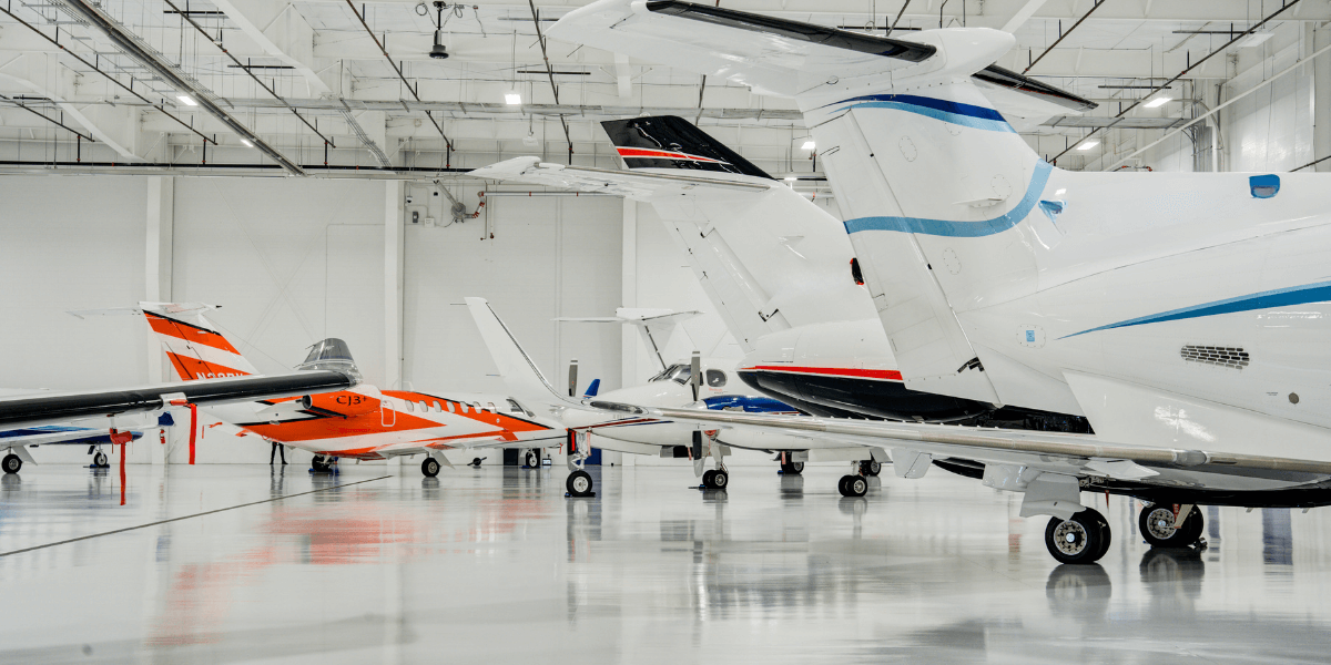 Multiple aircrafts parked in the Chantilly Air hangar.