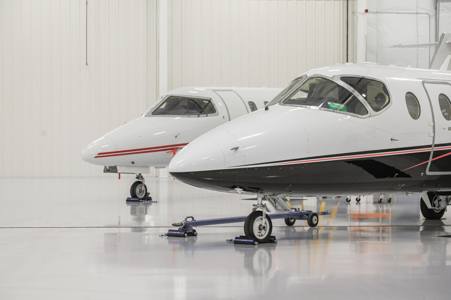 The front of two small planes in Chantilly Air's hangar.