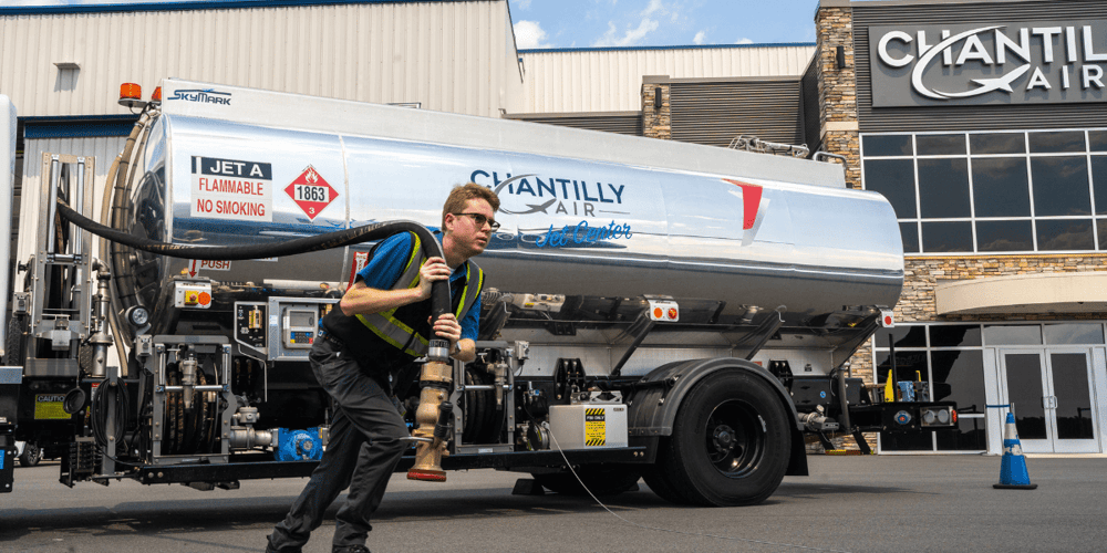 Mobile fuel truck with Chantilly Air employee rolling out fuel hose.