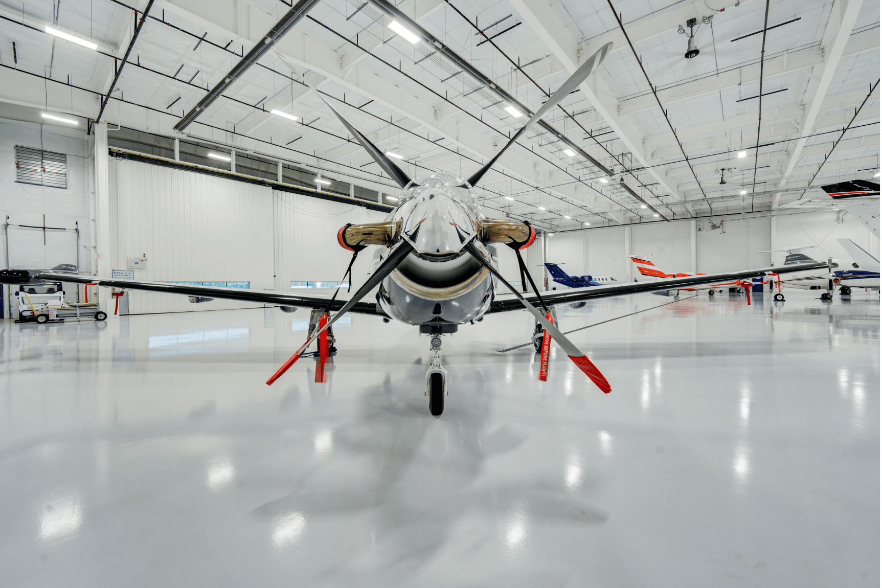 An aircraft stored in the all white Chantilly Air hangar.