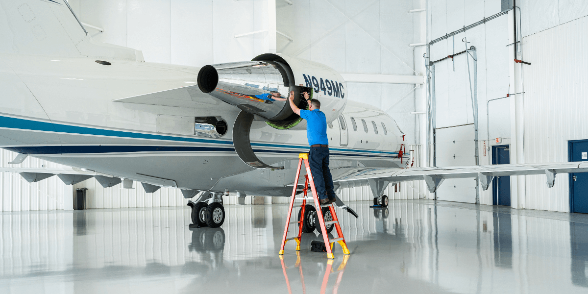 Chantilly Air maintenance tech working on an aircraft inside of the hangar