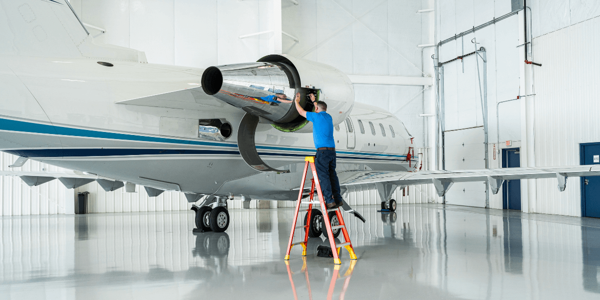 Chantilly Air maintenance tech working on an aircraft inside of the hangar