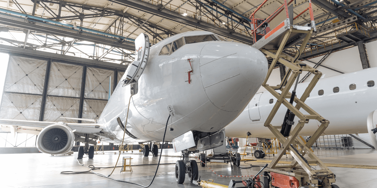 Aircraft maintenance being performed on a private jet in an airplane hangar