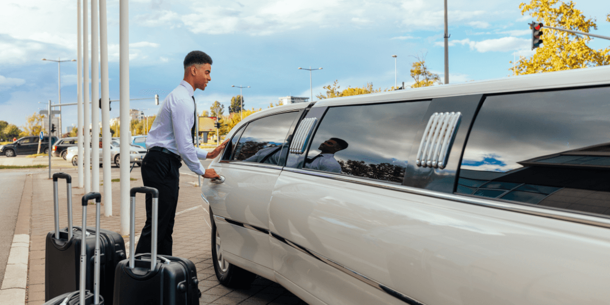 A white limo being opened by the driver.