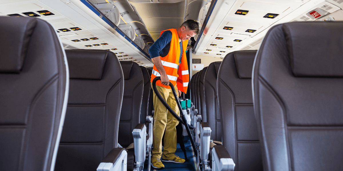 Employee cleaning airplane after travel.