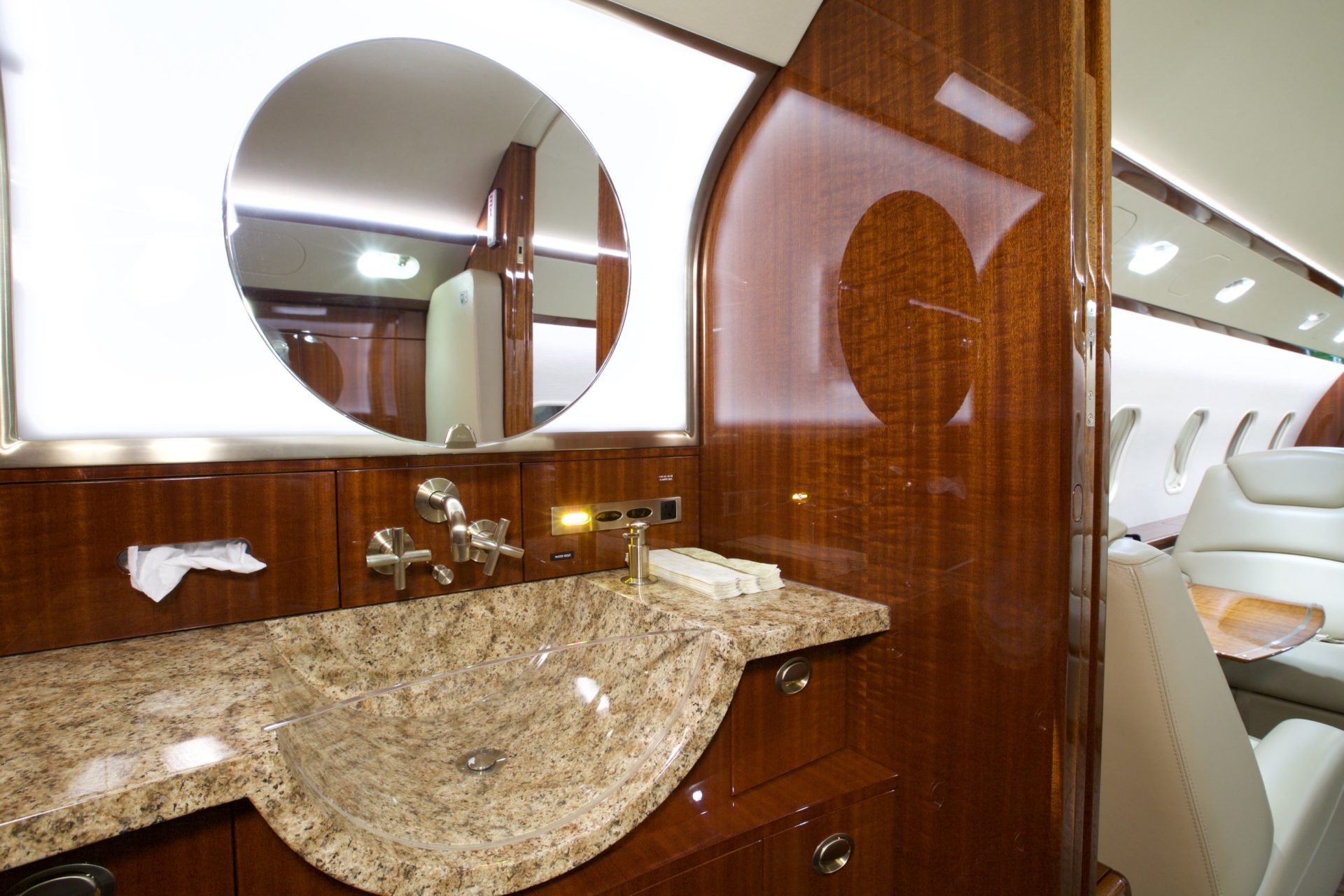 Marble bathroom sink and backlit round mirror